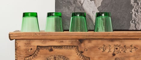 Un cofre de madera con tallas intrincadas y botellas de vidrio verde encima.