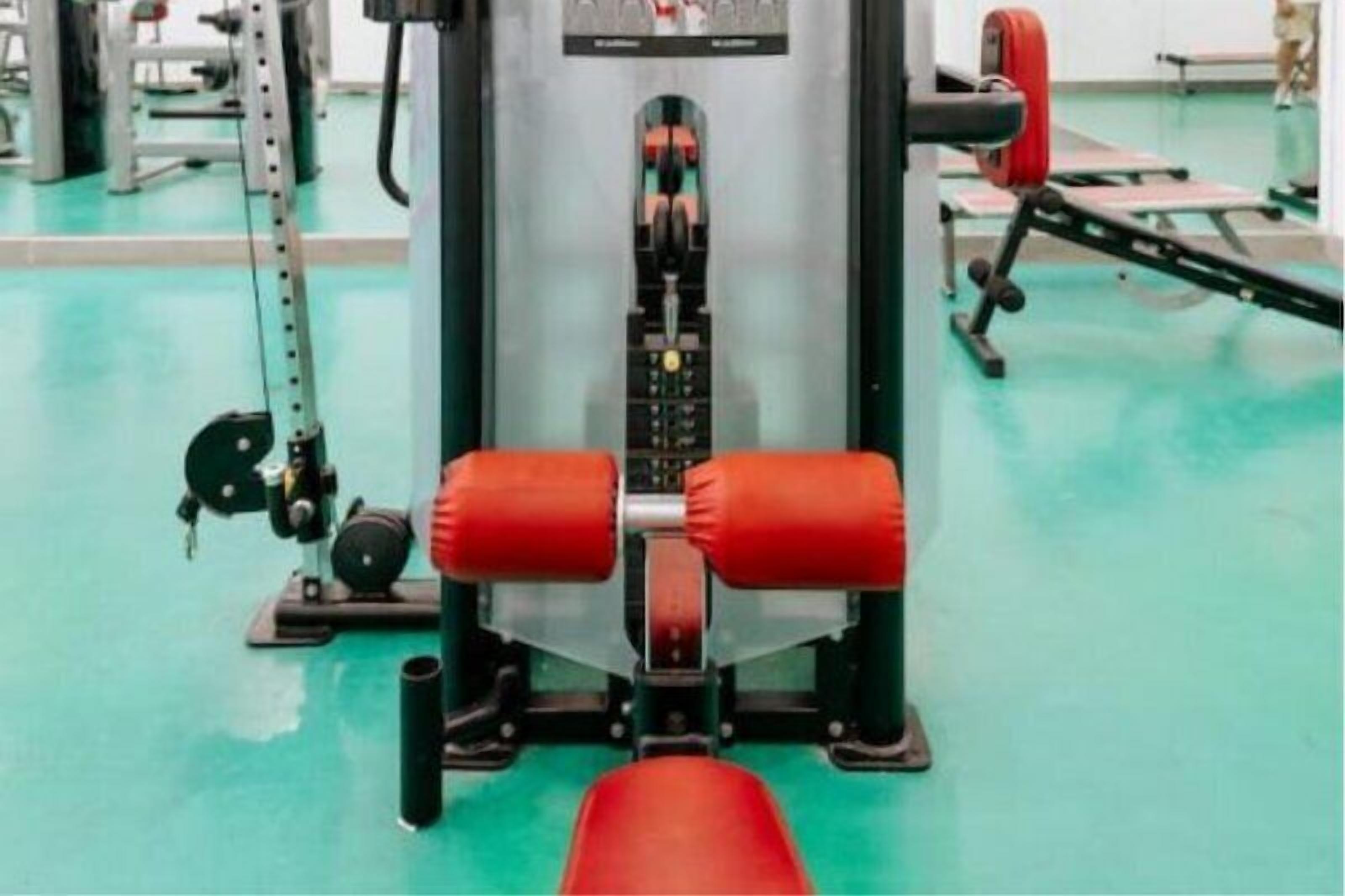 A gym with exercise equipment, including a bench and weights.