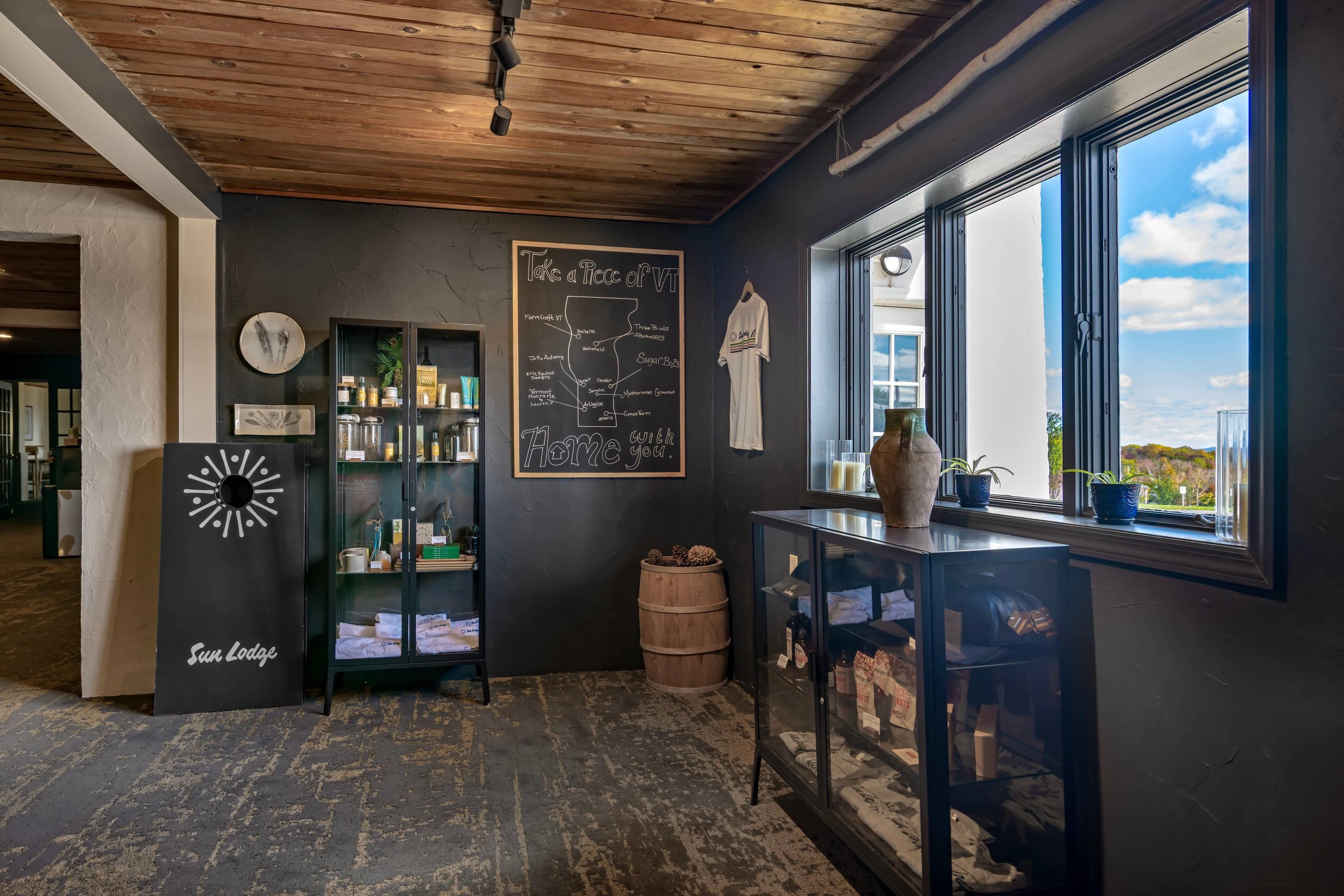 Una habitación con un menú en pizarra, un reloj, techo rústico, ventana con vistas y una zona de bar.