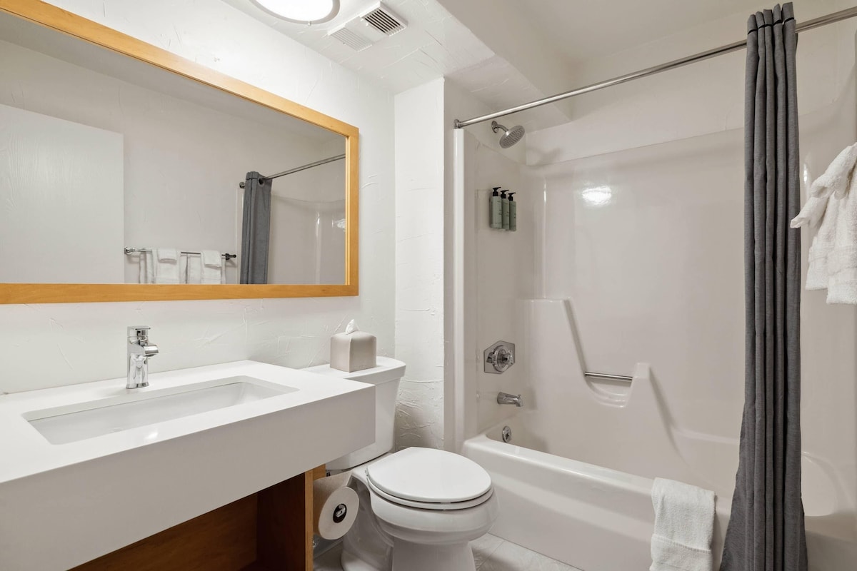 Un baño con lavamanos, inodoro y ducha.