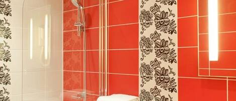 A modern bathroom with a glass-enclosed shower, a white toilet, and a sink with a mirror.
