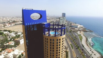 A high-rise building with a distinctive blue top and a circular window.