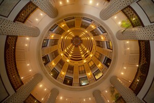 Un atrio circular con tragaluces centrales, varios niveles y elaboradas barandillas de celosía.