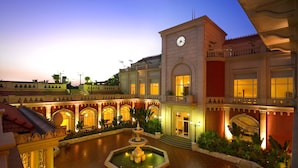 A courtyard with a fountain, a clock tower, and a building with multiple balconies and arches. - ITC Grand Central, a Luxury Collection Hotel, Mumbai (Mumbai)
