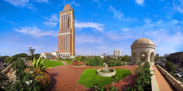 A tall building with a unique architectural design, a circular fountain, and a dome structure in a landscaped area. - ITC Grand Central, a Luxury Collection Hotel, Mumbai (Mumbai)