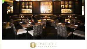 A restaurant interior with round tables, patterned chairs, and pendant lighting. - The Birchwood (St. Petersburg)