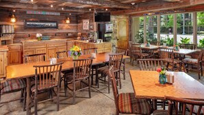 A rustic interior with wooden furniture, a kitchen area, and large windows. - Annabelle Inn (Aspen)