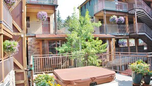 A multi-story building with balconies, wooden railings, and potted plants.