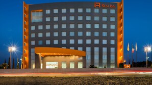 A multi-story hotel with a prominent 'Real Inn' sign, featuring a modern design with a curved entrance and multiple windows. - Real Inn San Luis Potosí (San Luis Potosi)