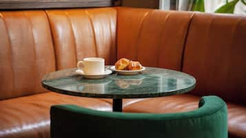 Een leren bank met een ronde tafel en een groene stoel.