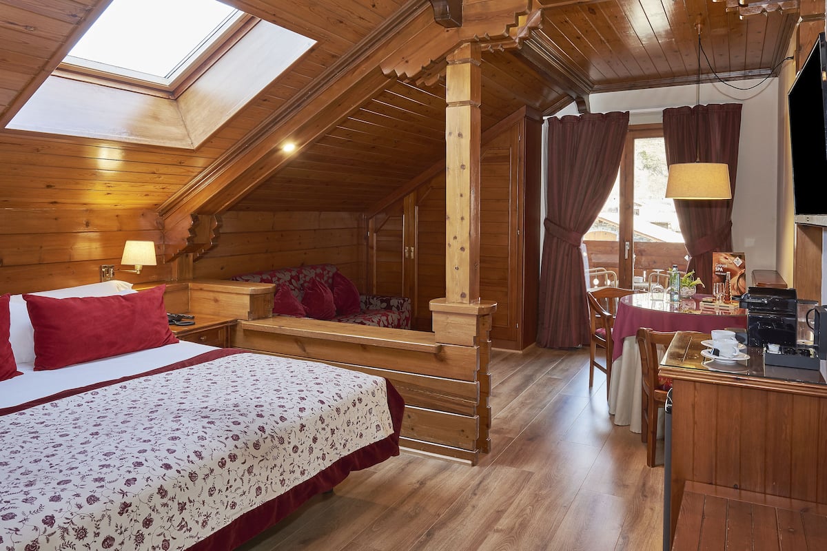 Eine Holzhütte mit Schlafzimmer auf dem Dachboden, Essbereich und Küche.