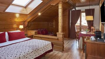 A wooden cabin with a loft bedroom, a dining area, and a kitchen.