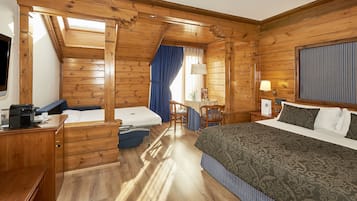Een kamer met houten vloeren, een bed, een bureau, een stoel en een tafel.