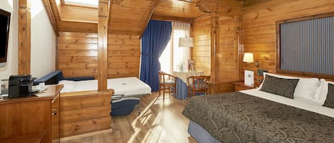 Una habitación de madera con una cama, un escritorio, una silla y una mesa.