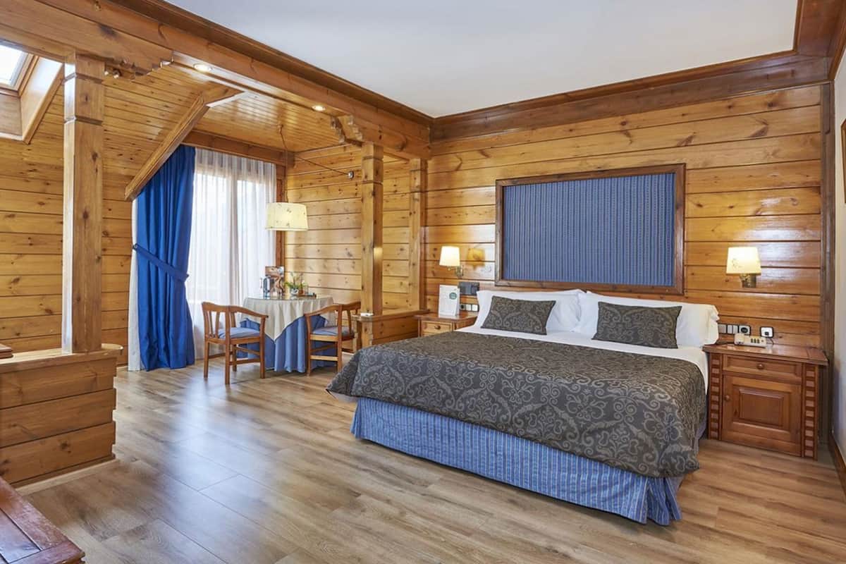 Ein Zimmer mit Holzboden, einem Bett, einem Schreibtisch und einem Stuhl.