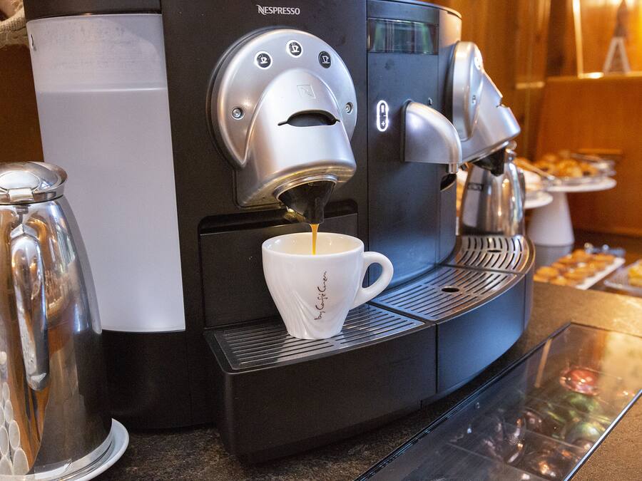 Una máquina de café Nespresso vertiendo café en una taza.