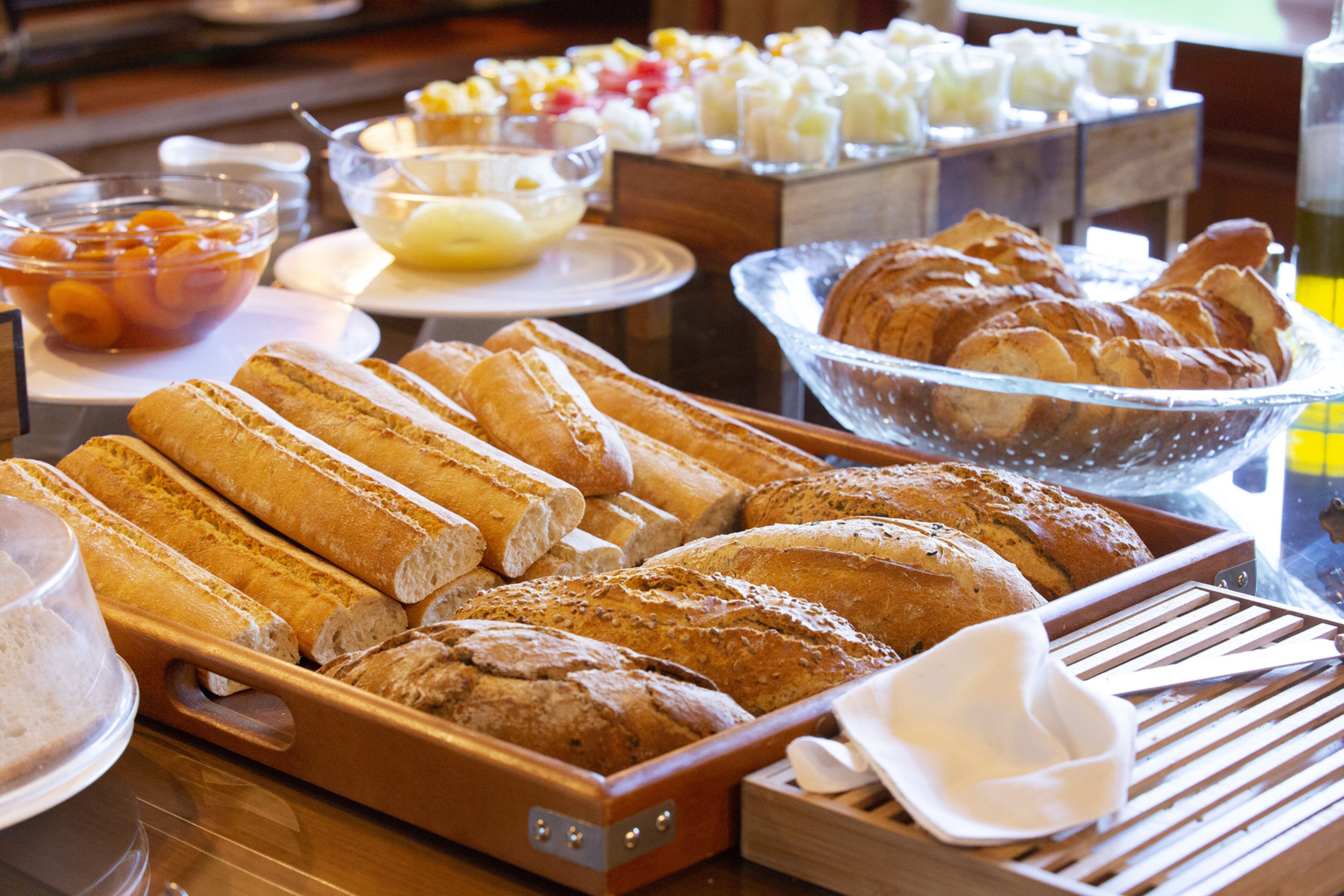 A buffet with various breads and pastries.