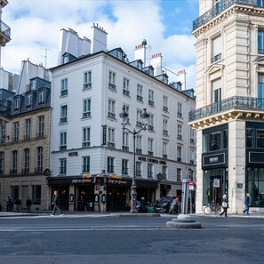 A hotel with a classic facade, multiple windows, and a sign indicating it is a hotel. - Choiseul Opera (Paris)