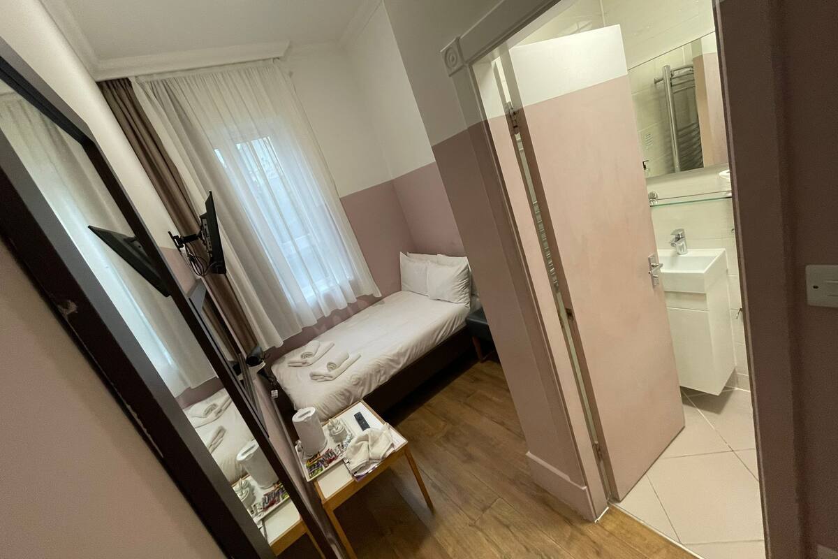 Economy tweepersoonskamer, en-suite badkamer | Een kluis op de kamer, een bureau, een strijkplank/strijkijzer