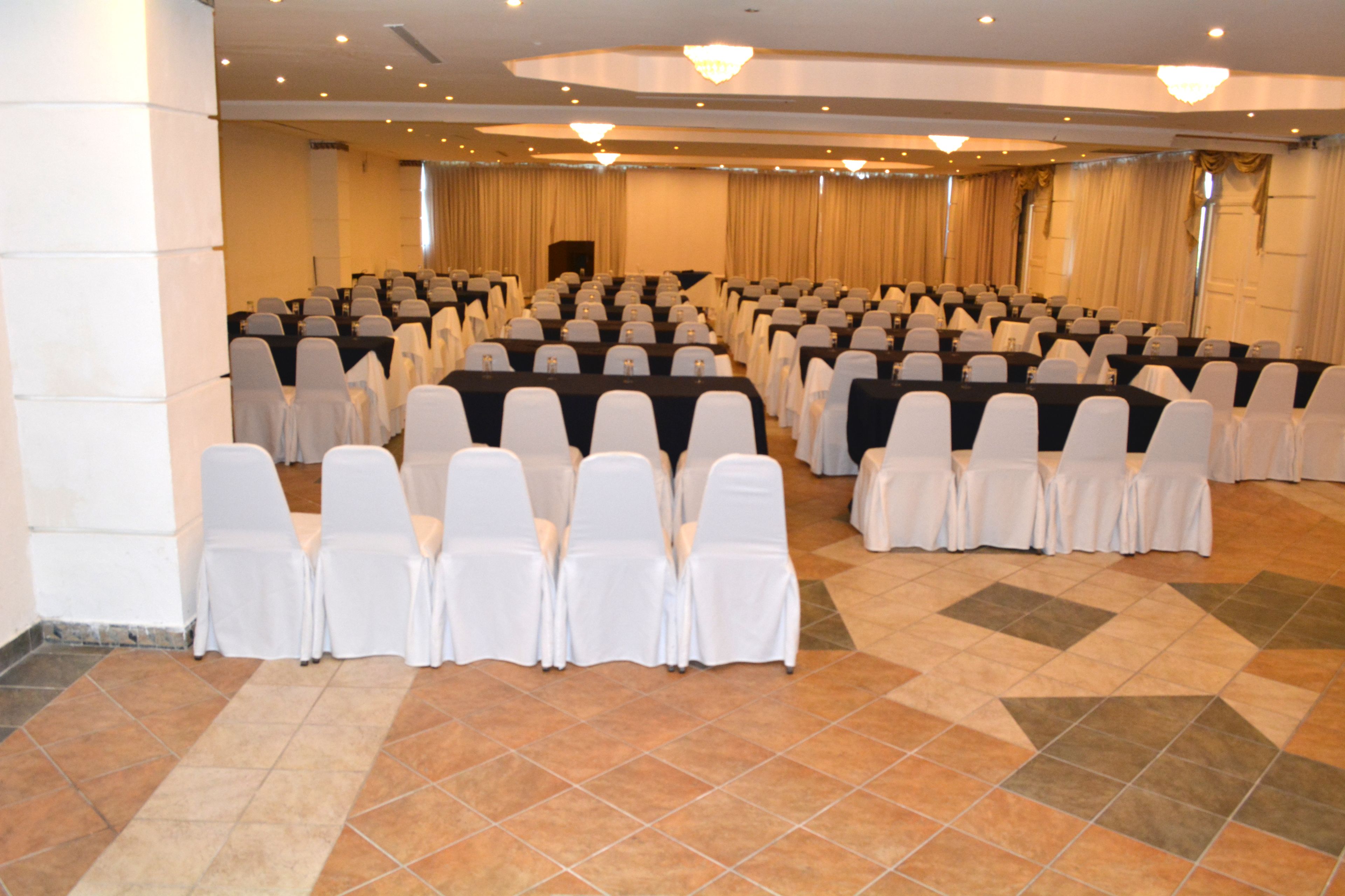 A conference room with rows of chairs and tables, arranged for a meeting or event.