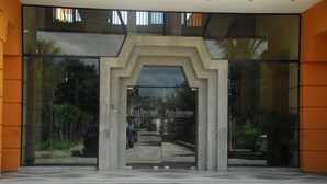L’entrée d’un hôtel, avec une façade en verre, une arche en béton et le nom « Peten Esplendido » inscrit sur le verre.