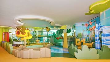A children's play area with soft seating, a slide, and colorful decorations.
