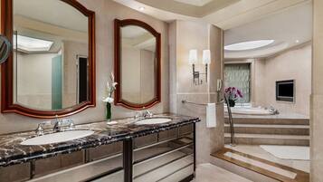 A modern bathroom with two sinks, large mirrors, and a bathtub.