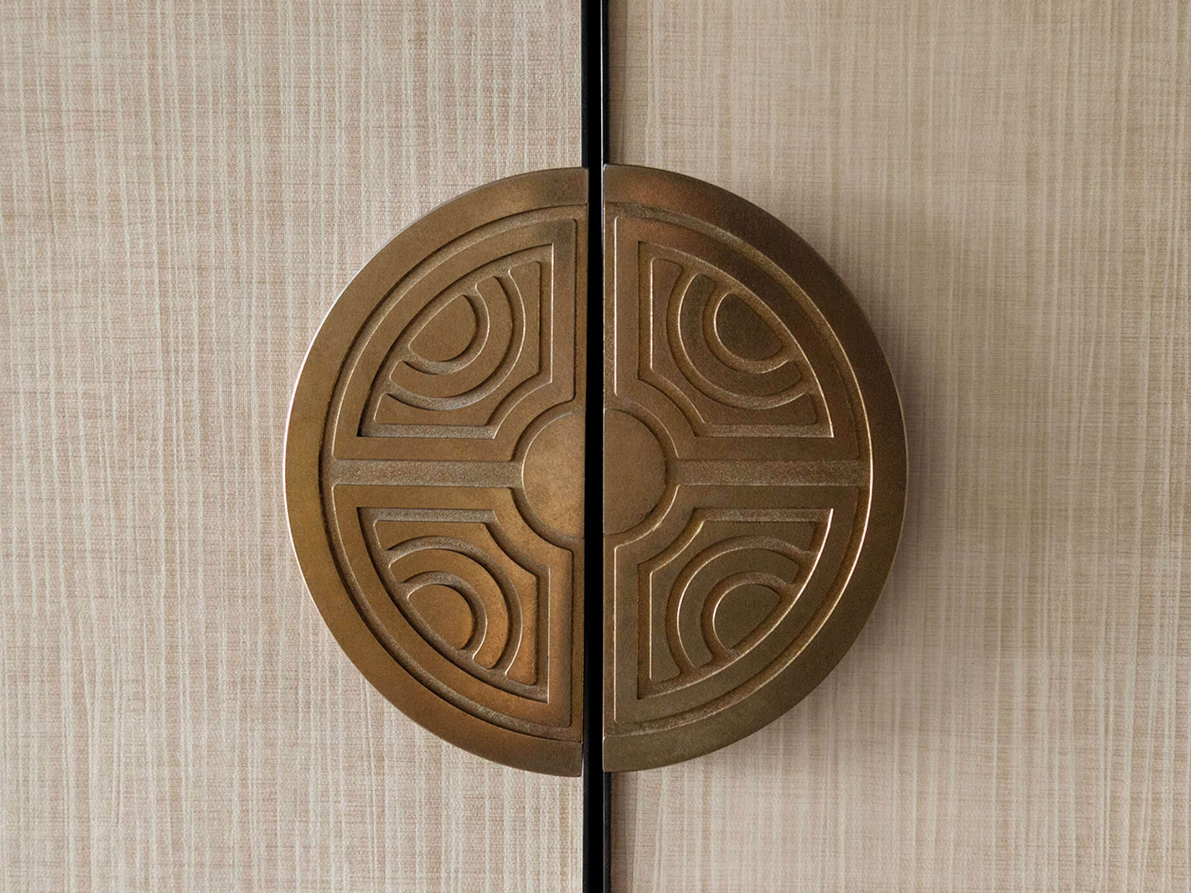 A circular door with a symmetrical design, featuring geometric patterns and a central circular motif.