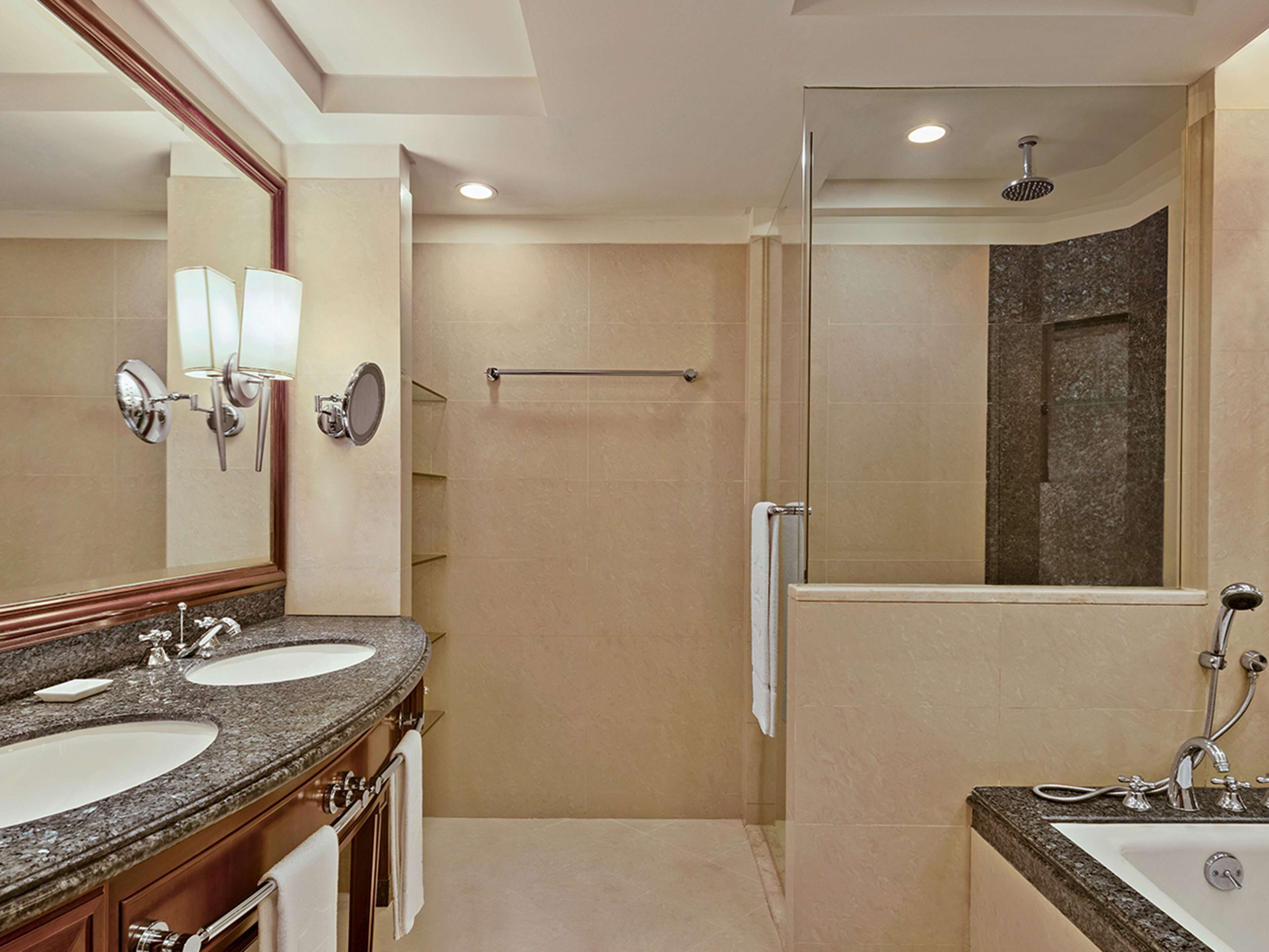 A modern bathroom with two sinks, a shower, and a glass-enclosed walk-in shower.