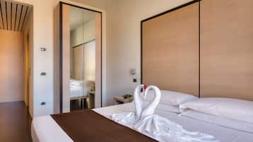 Ein Hotelzimmer mit Bett, Holz-Kopfteil, Spiegel und Tür.