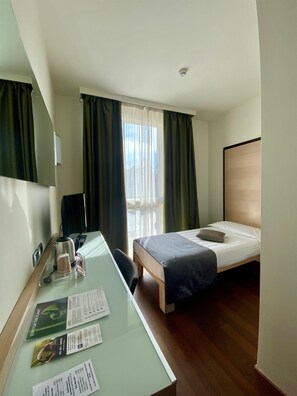 A hotel room with a bed, a desk with a computer, a kettle, and a coffee cup. - Best Western Hotel San Marco (Siena)
