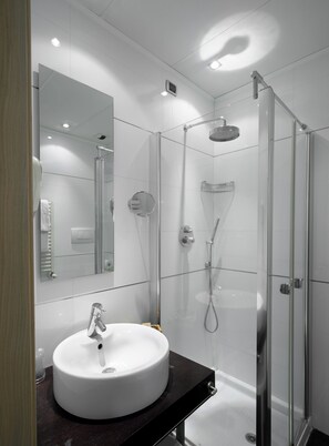 A modern bathroom with a round sink, a glass shower enclosure, and a large mirror. - Best Western Hotel San Marco (Siena)
