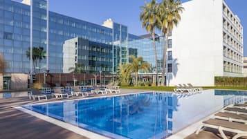 Una piscina al aire libre de temporada, sillones reclinables de piscina