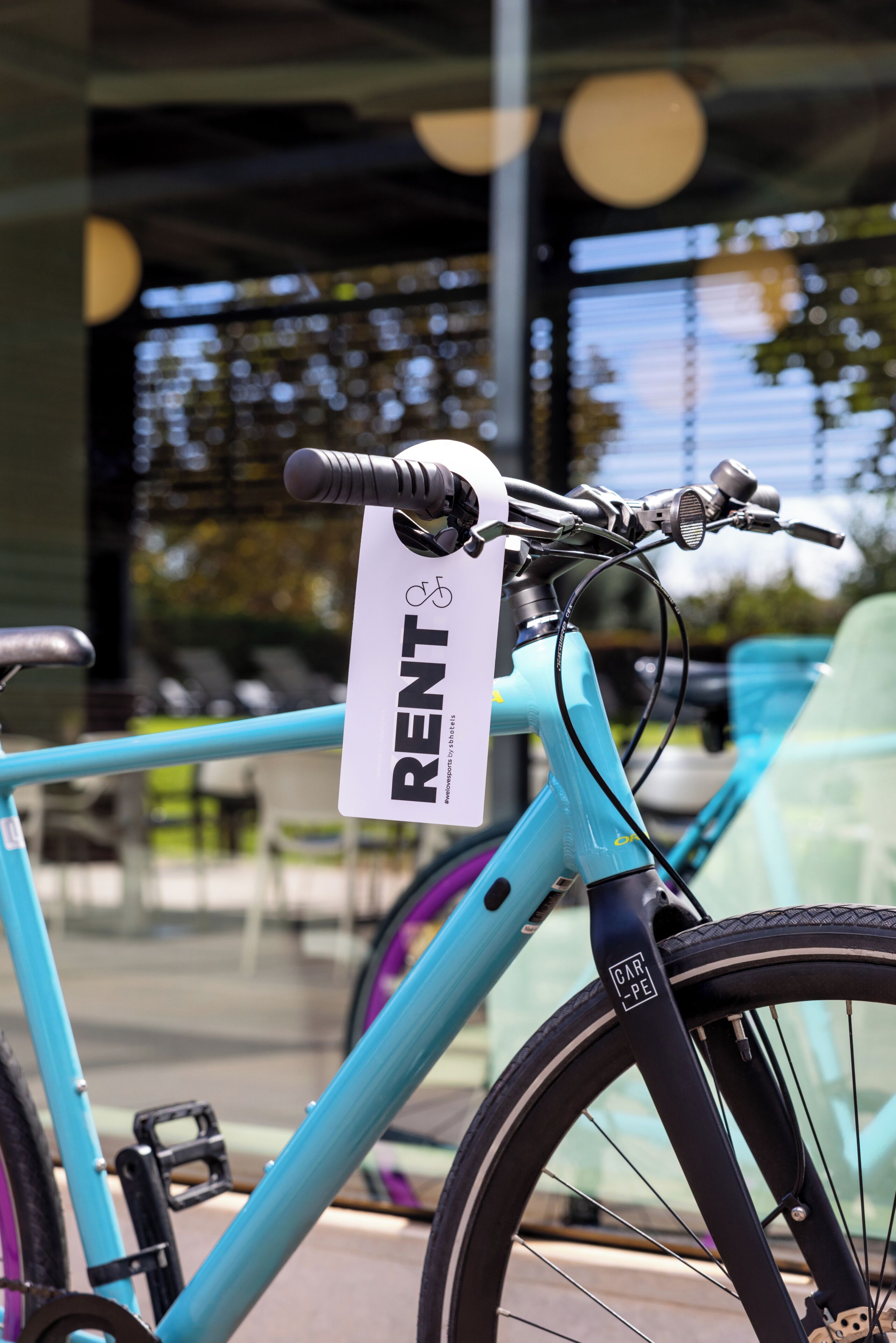 A bicycle with a 'RENT' sign attached to it, indicating a rental service.
