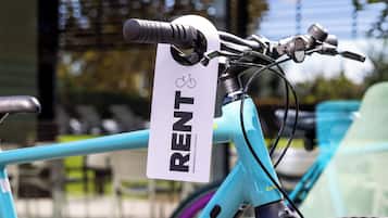 A bicycle with a 'RENT' sign attached to it, indicating a rental service.