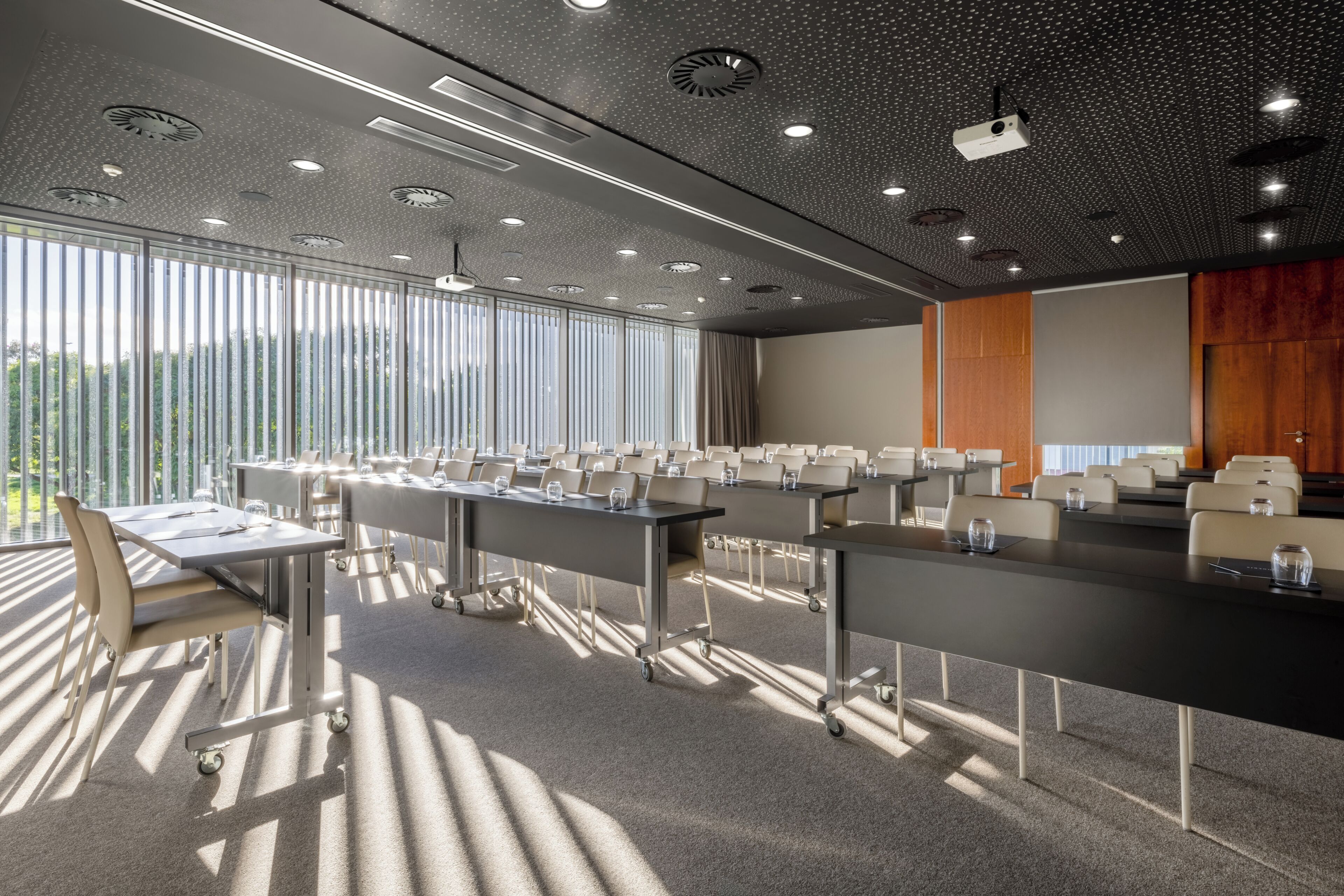 Ein Konferenzraum mit einem langen Tisch, Stühlen und einem Projektor.