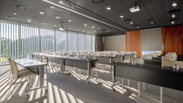 Ein Konferenzraum mit einem langen Tisch, Stühlen und einem Projektor.