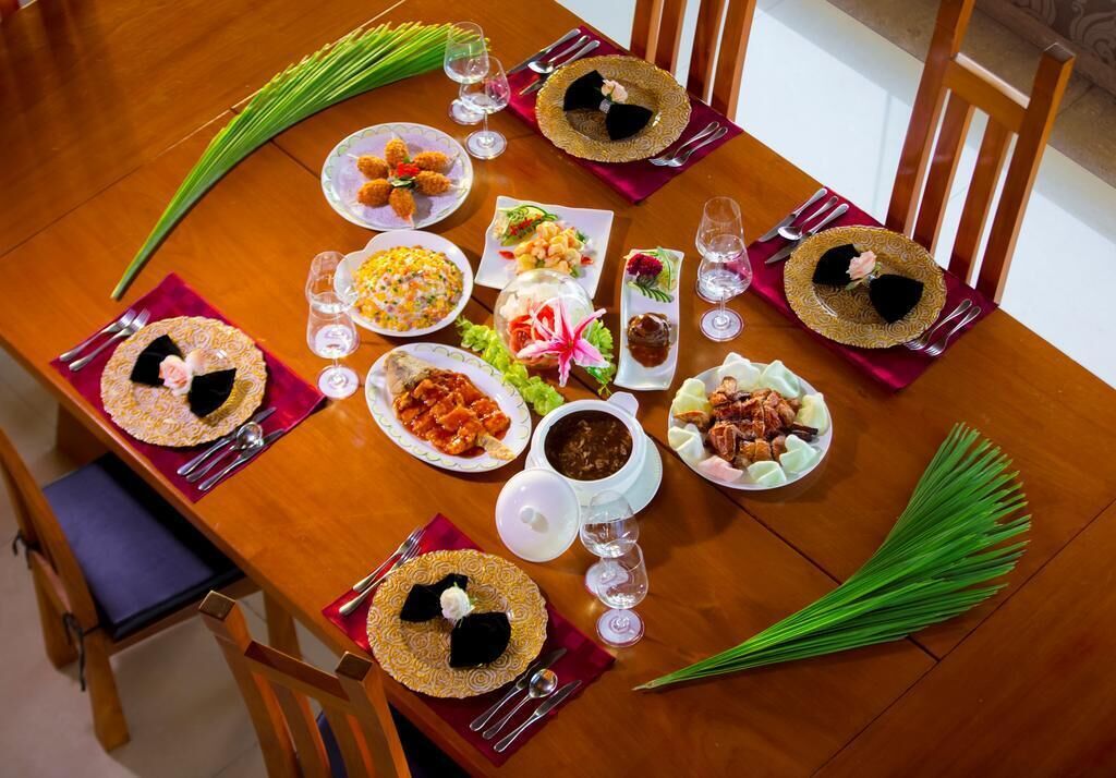 A dining table set with various dishes, glasses, and cutlery, surrounded by chairs.