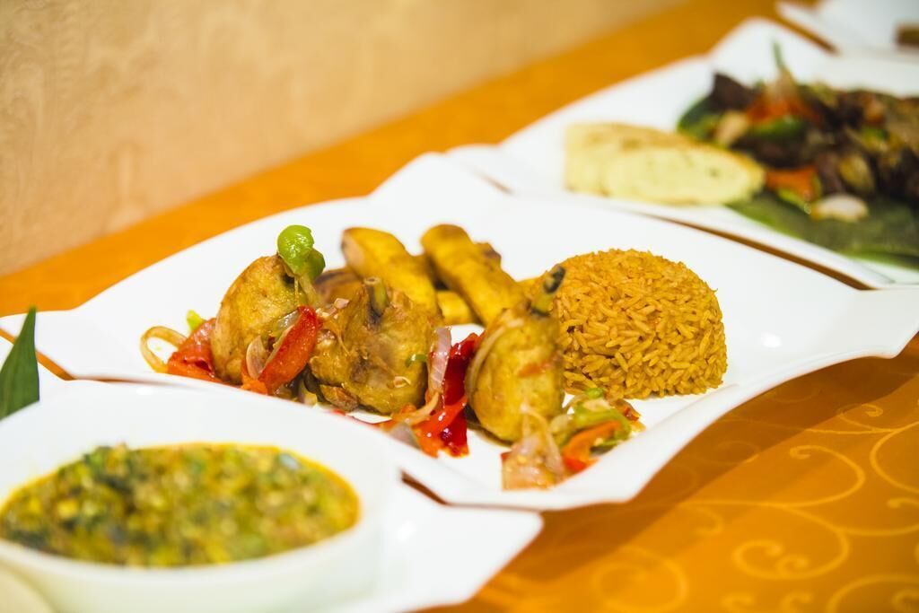 Una mesa con varios platos, incluyendo arroz, verduras y un bol de salsa.