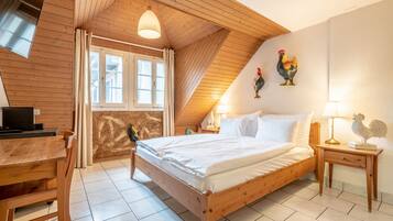 Un dormitorio acogedor con una cama de madera, un escritorio y una ventana con cortinas.