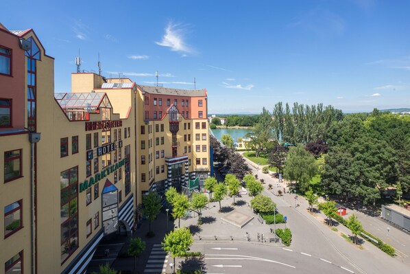 A hotel with a central courtyard, a lake view, and a mix of modern and traditional architecture. - Hotel Maximilian (Weil am Rhein)