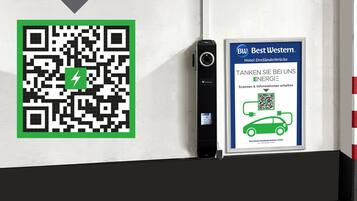 A QR code and a sign for Best Western Hotel Dreiländerbrücke with a car charging station.