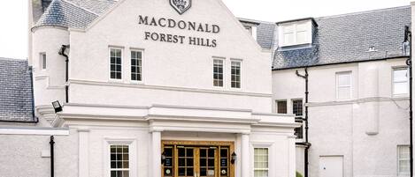 A white building with a sign reading "Macdonald Forest Hills".