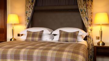 A hotel room with a large bed, two bedside lamps, and floral curtains.