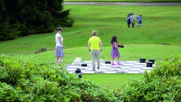 Guests can enjoy a game of checkers in the lush outdoor space surrounded by greenery.