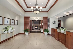 A spacious lobby with a fireplace, a reception desk, and potted plants. - Staybridge Suites Chantilly - Dulles Airport by IHG (Chantilly)