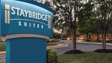 A sign for Staybridge Suites with a curved design and the name prominently displayed.