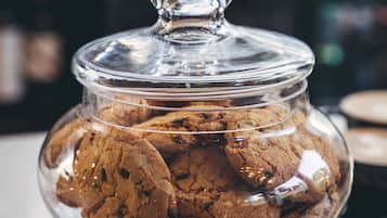 A glass jar filled with cookies on a table.