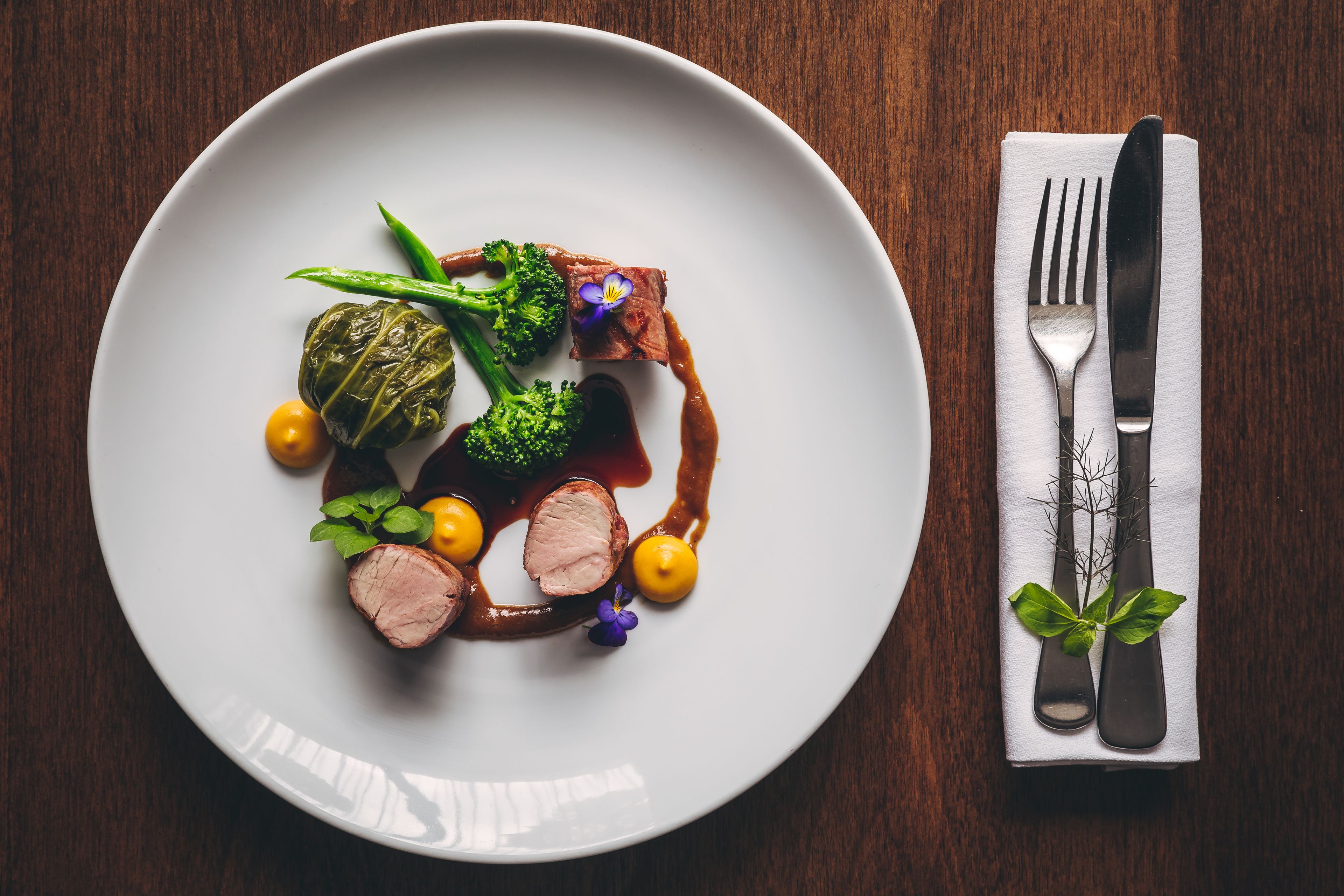 A plate of food with a fork and knife on a napkin.