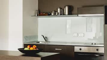 Eine moderne Küche mit Kochinsel, Edelstahlgeräten und einer Spritzschutzwand.
